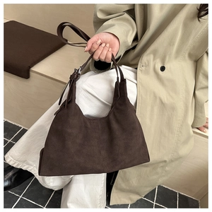 Detail of dark brown faux suede Hobo bag with adjustable metal buckle on a trench coat
