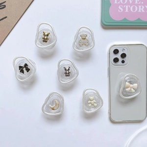Detail of 3D resin bear and bow phone grip tok with pearl edges on a clear smartphone case