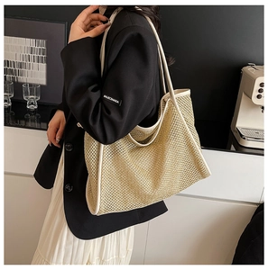 Close-up of the woven texture and white piping on this large beige straw tote bag