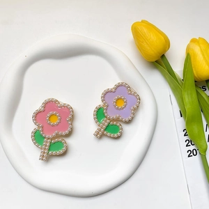 Gros plan de supports de téléphone fleurs avec perles et feuilles vertes sur plateau