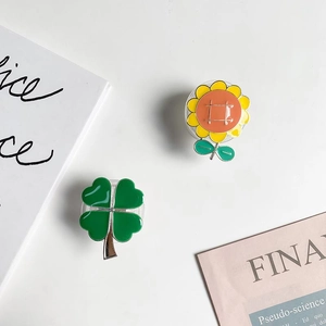 Detail of sunflower and four-leaf clover phone grips with glossy electroplated finish