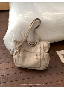 Detail of khaki corduroy tote bag showing vertical ribbed texture and front zipper pocket