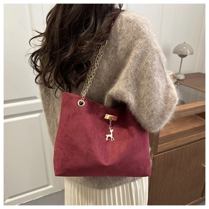 Retro burgundy frosted tote bag with chain strap and golden deer charm on model