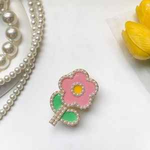 Détail du support de téléphone en fleur rose avec feuilles vertes et perles blanches