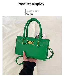 Detail of green leather handbag featuring a signature gold heart-shaped metal clasp