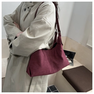 Detail der burgunderroten Wildleder-Hobo-Tasche mit verstellbarer Silberschnalle und Ziernaht