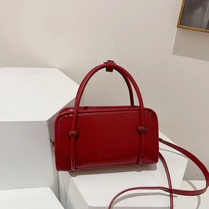 Minimalist red leather crossbody handbag with top handles and fashion embossed logo