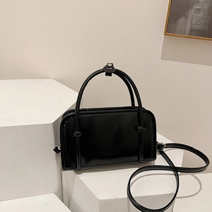 Minimalist black patent leather handbag with FASHION embossing and shoulder strap