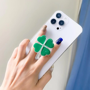 Green four-leaf clover phone grip with silver edge on mobile back case