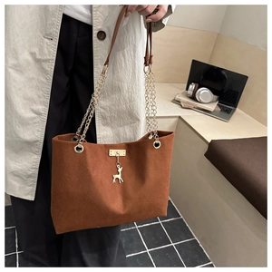 Detailed shot of retro tote bag with gold deer pendant and chain leather shoulder strap