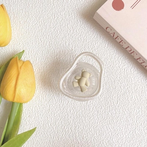 Detail of transparent baby pacifier with a cute beige matte bear on a minimalist background