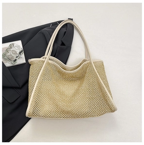 Detail view of metallic woven mesh tote bag with smooth leather edges and handles
