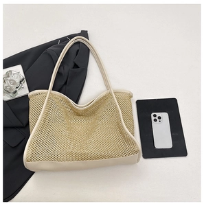 Detail of woven mesh tote bag with beige PU leather straps and minimalist beach style