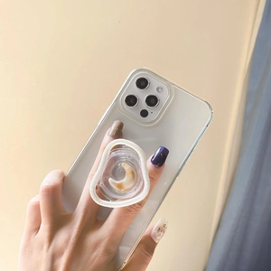 Detail of transparent iPhone case with yellow crescent moon pop socket held by hand