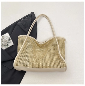 Detail of hollow woven tote bag with PU leather trim and handles on a black blazer