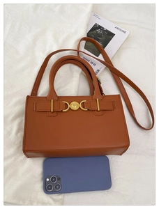 Borsa a tracolla marrone in ecopelle con chiusura a cuore e cellulare per scala dimensionale