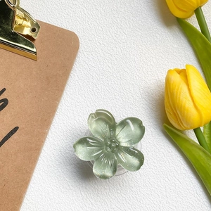 Detail of light green floral phone grip with glitter finish on a fresh spring background