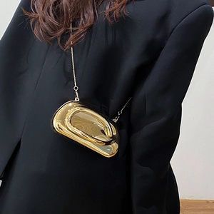Close-up of a gold oval mirror-finish crossbody bag with thin metal chain strap