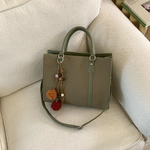Borsa tote intrecciata verde oliva con finiture in pelle e ciondolo decorativo con perle