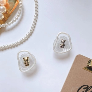 Detailed view of gold and silver bear-themed phone grips on an elegant decorative tray