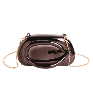 Minimalist bronze clutch bag with gold chain and unique oval handle on white background