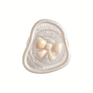 Collapsible phone grip with cream-colored 3D ribbon bow and translucent textured base