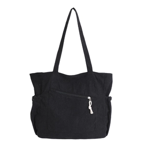 Large black corduroy tote bag with vertical stripes and front zipper pocket detail