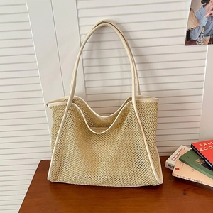 Large beige woven straw tote bag with white leather handles for beach or commute