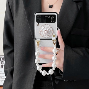 Détail de la fleur de camélia blanche avec perles et strass sur la coque Samsung Z Flip