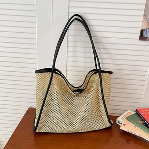 Large woven straw tote bag with black leather straps for beach and commuting