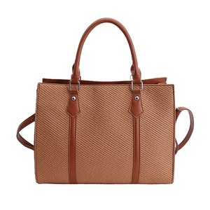 Brown woven crossbody handbag with top handle and spacious interior for commuting