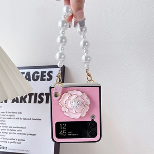 Détail de coque Galaxy Z Flip avec fleur de camélia 3D et dragonne en perles