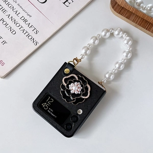 Détail de coque Z Flip avec fleur de camélia noire et chaîne de perles de luxe