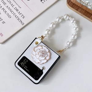 Détail d'étui Galaxy Z Flip avec fleur de camélia de luxe et poignée en perles