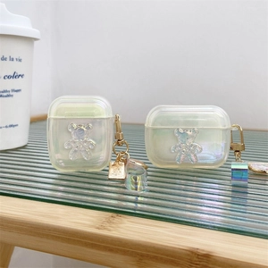 Détail de la coque AirPods aurore laser avec relief d'ours en 3D et breloque colorée