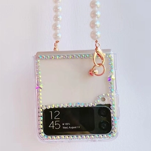 Detail of clear folding phone case with colorful rhinestones and pearl crossbody strap