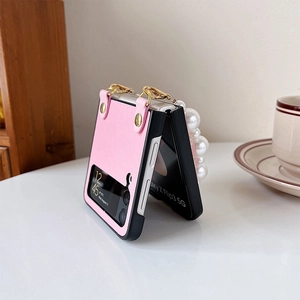 Detailed view of pink leather Samsung Z Flip3 case with elegant white pearl wrist strap