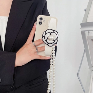 Elegant iPhone 16 Pro Max case featuring a camellia flower, pearl strap, and crossbody chain