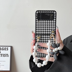 Houndstooth Samsung Z Flip case with pearl handle and balloon dog charm on hand