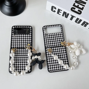 Close-up of houndstooth Z Flip case with pearl handle and balloon dog charms
