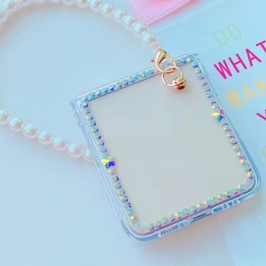 Detailed view of clear phone case with iridescent rhinestones and pearl hand strap