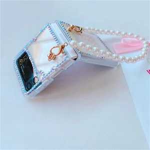 Detail of clear Z Flip case with sparkling rhinestones and a white pearl handle strap