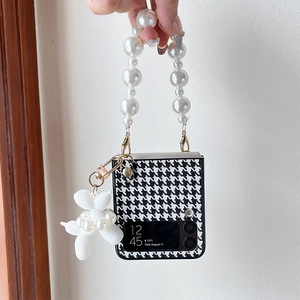 Detail of Galaxy Z Flip case with houndstooth pattern, pearl handle and balloon dog charm