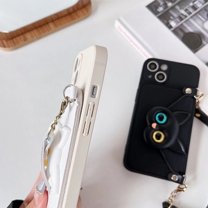 Detailed close-up of cat-themed phone case with leather card holder and metal chain strap