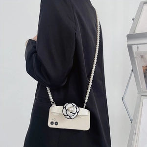 White camellia phone case with long pearl shoulder strap shown on a model for iPhone
