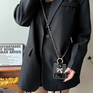 Black leather Galaxy Z Flip case with rhinestone bow and crossbody strap shown on a model