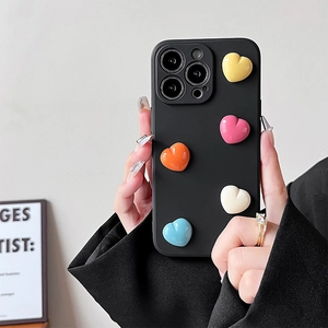 Dettaglio di custodia nera per telefono con cinque cuori 3D colorati in mano