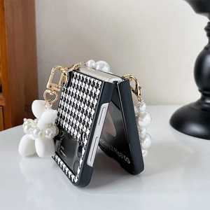 Detail of Galaxy Z Flip case with pearl strap, houndstooth pattern and dog charm
