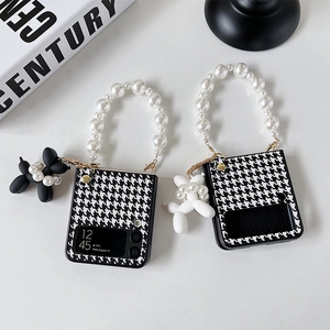 Detail of houndstooth Z Flip case with pearl handle and balloon dog charm