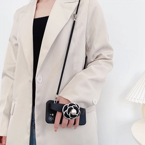 Crossbody iPhone case with camellia wrist strap, pearl accent and black lanyard strap